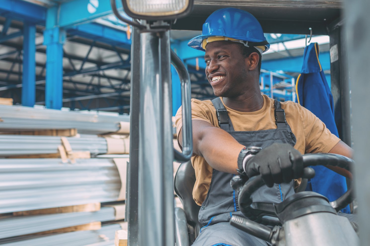 Construction worker riding a loader in a factory