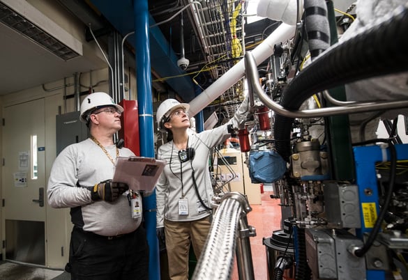 two persons of the manufacturing industry who are reviewing a pipe construction