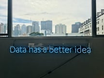 neon letters about data in front of a skyline